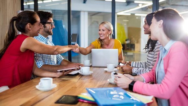 Sales woman making salespitch to a business around a meeting table