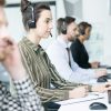 Customer service team sitting at computers answering customer phone calls