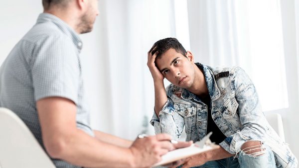 Two individuals sitting opposite one another having a difficult conversation